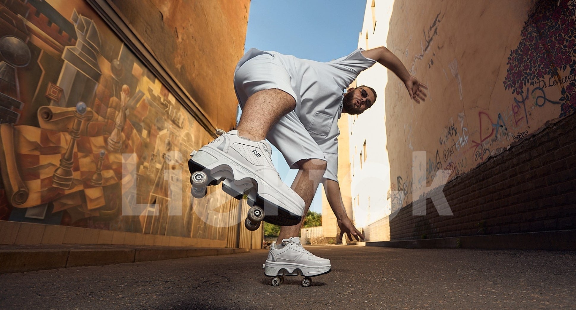 Man performing a dynamic trick in Liekick transformable roller shoes, capturing urban energy and movement in a graffiti-lined alleyway.