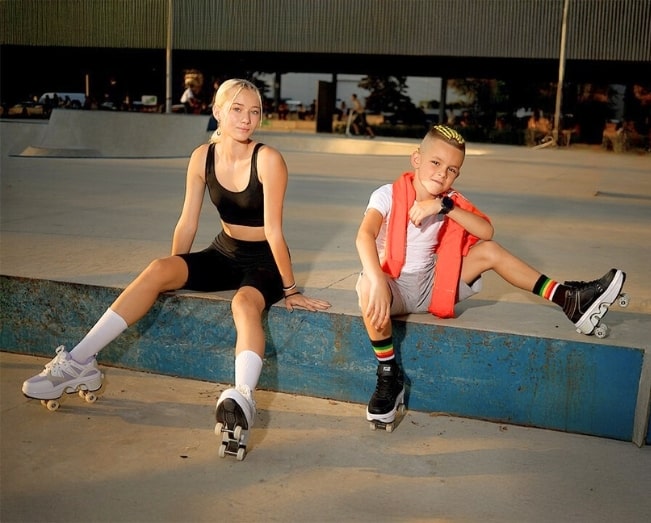 Two kids wearing roller shoes